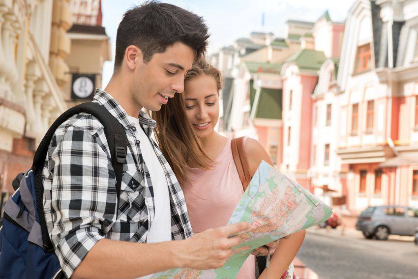 Un couple en voyage observe une carte