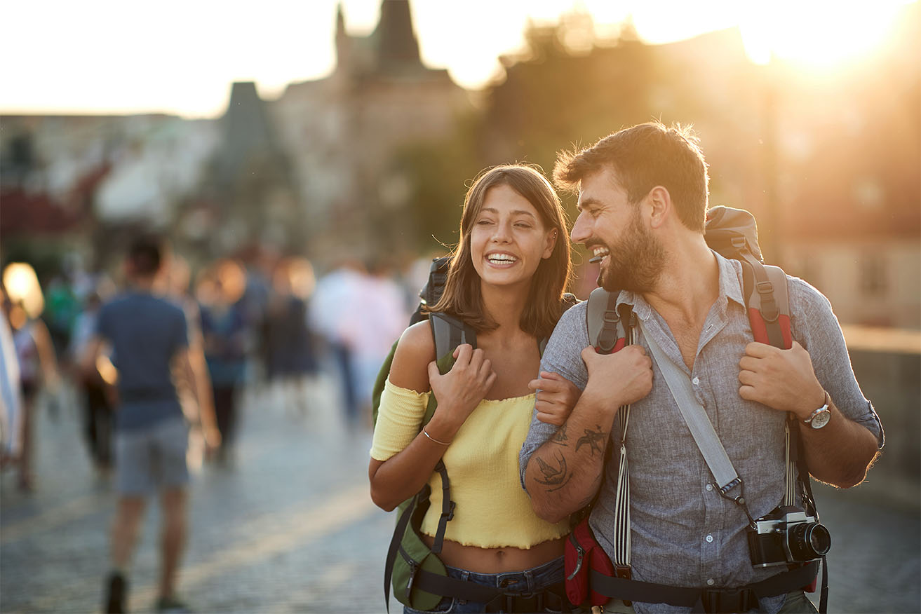 Couple de voyageurs souriants dans une destination touristique. 