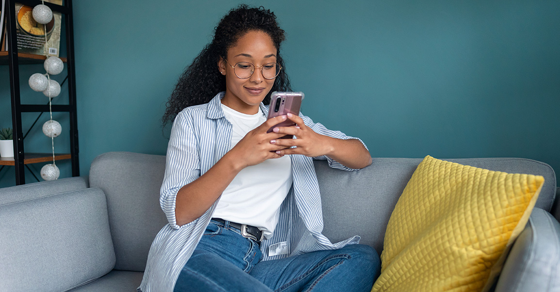 Femme sur son canapé consultant son cellulaire