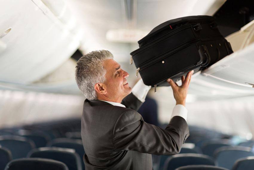 Un homme met son bagage dans l'avion
