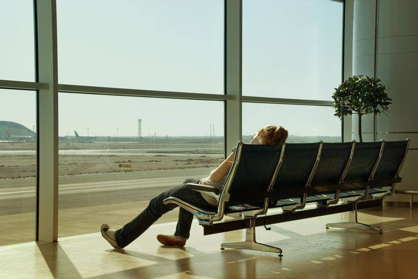 Madame assise dort à l'aéroport