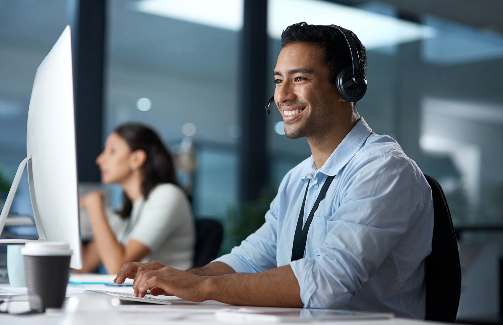  Personne portant un casque audio travaillant sur un ordinateur dans un bureau. 