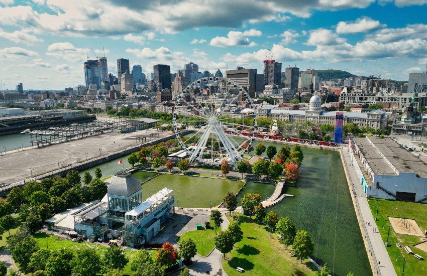 Vue aérienne du Vieux‑Port de Montréal et du centre‑ville, avec la Grande Roue et des espaces verts.