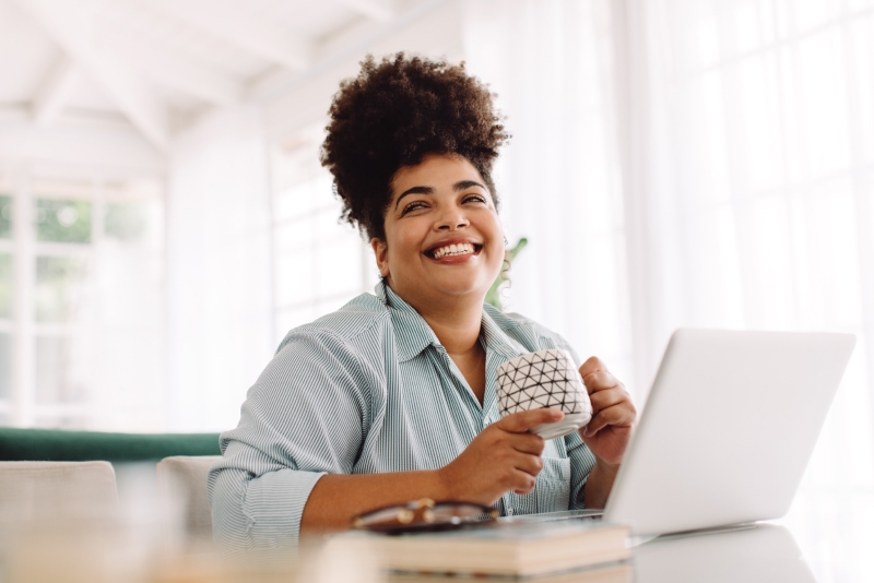 Femme souriante devant son portable
