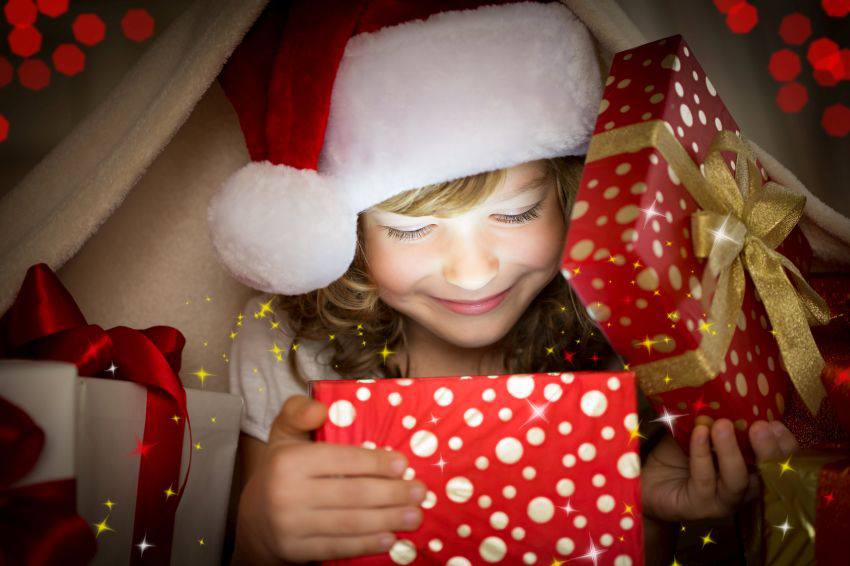 Une enfant ouvre un cadeau de Noël