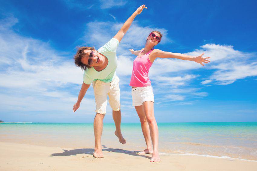 Deux personnes heureuses sur le bord d'une plage 