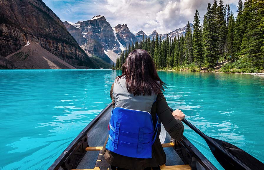 Touriste faisant du canoë sur le lac Moraine dans le parc national Banff, dans les Rocheuses canadiennes, en Alberta, Canada. 