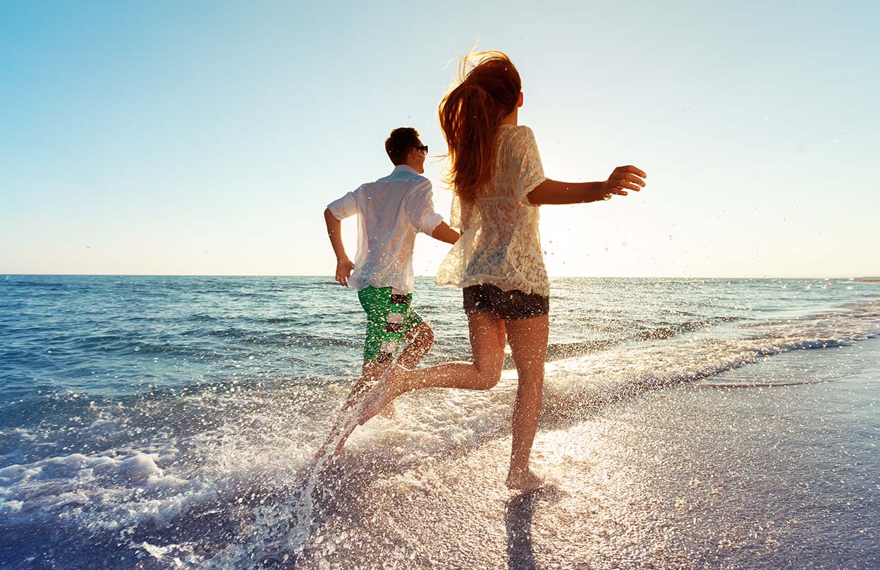 Jeune couple heureux profitant de la mer lors de vacances à la plage. 