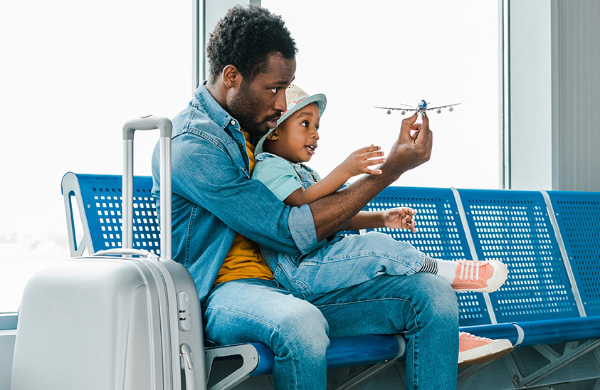 Père et fils attendant l’avion assis à l’aéroport