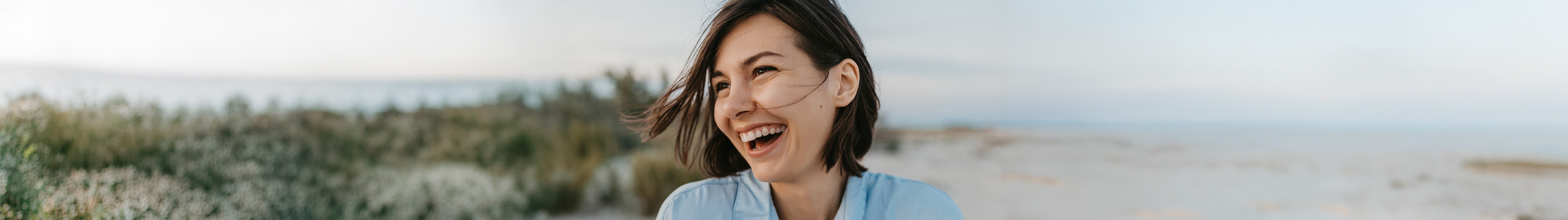 Portrait d’une personne souriante éclatant de rire spontanément.