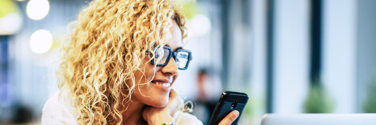 Woman smiling and looking at her mobile phone